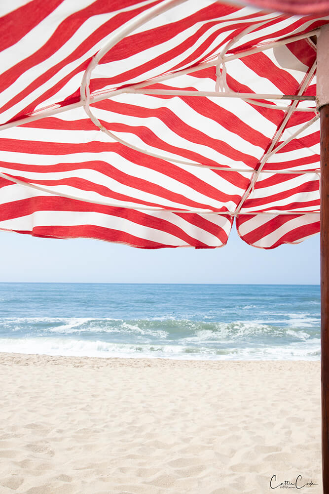 Beach umbrella at Praia da Aguda, Portugal by Cattie Coyle Photography. © 2024, all rights reserved.
