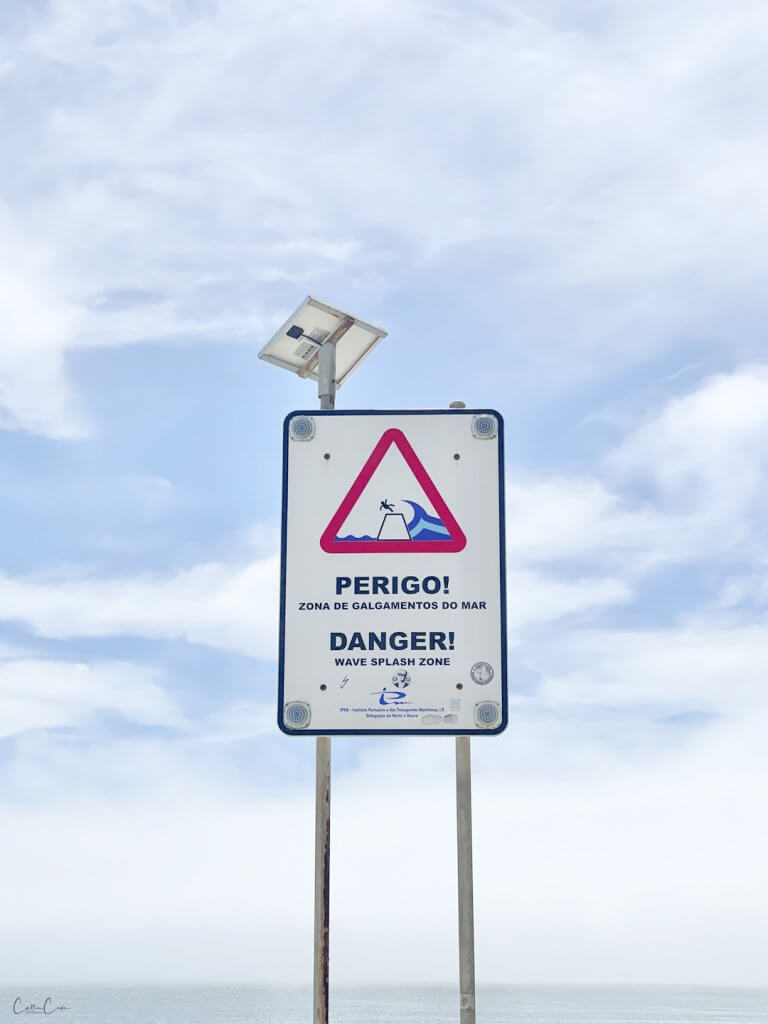 Warning sign at the Farolim da Barra do Douro, Foz, Porto, Portugal by Cattie Coyle Photography. © 2024, all rights reserved.